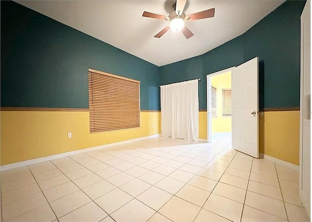 tiled spare room featuring ceiling fan