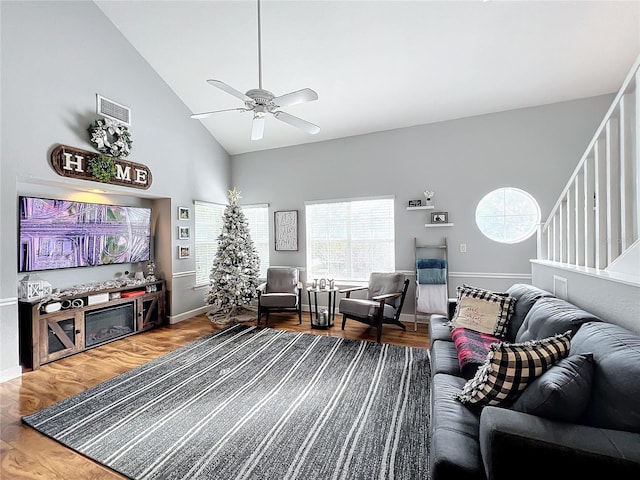 living room with hardwood / wood-style flooring, high vaulted ceiling, and ceiling fan