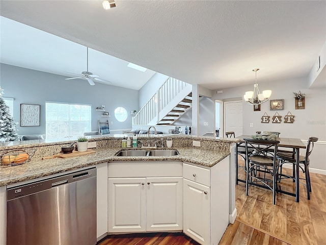 kitchen with ceiling fan with notable chandelier, sink, stainless steel dishwasher, hardwood / wood-style flooring, and white cabinetry