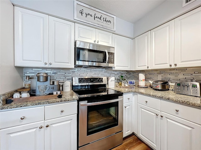 5269 Wellington Park Cir Unit 23, Orlando, FL 32839 - kitchen with appliances with stainless steel finishes, backsplash, and white cabinets