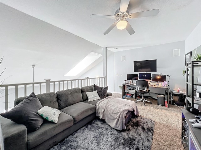 carpeted living room featuring vaulted ceiling with skylight and ceiling fan