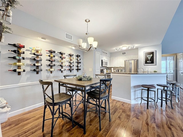 dining room with a notable chandelier and wood-type flooring