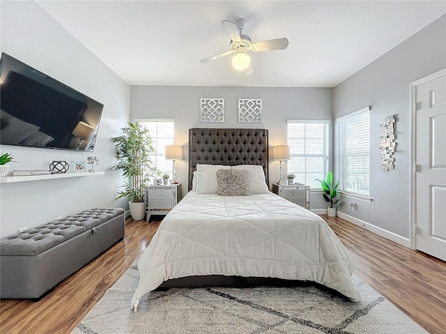 bedroom featuring multiple windows, ceiling fan, and hardwood / wood-style floors