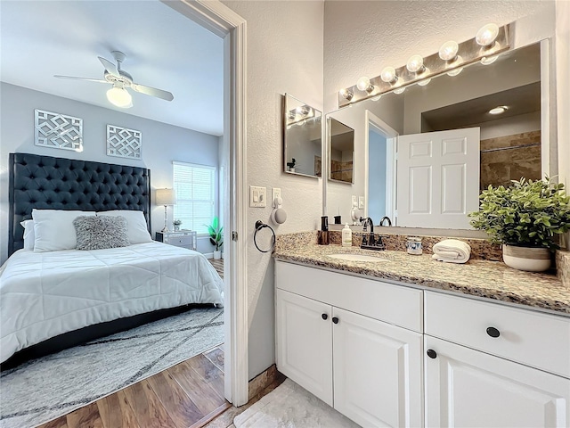 bathroom with ceiling fan, vanity, and hardwood / wood-style flooring