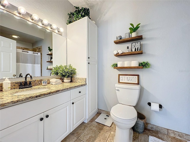 bathroom featuring a shower with shower curtain, vanity, and toilet