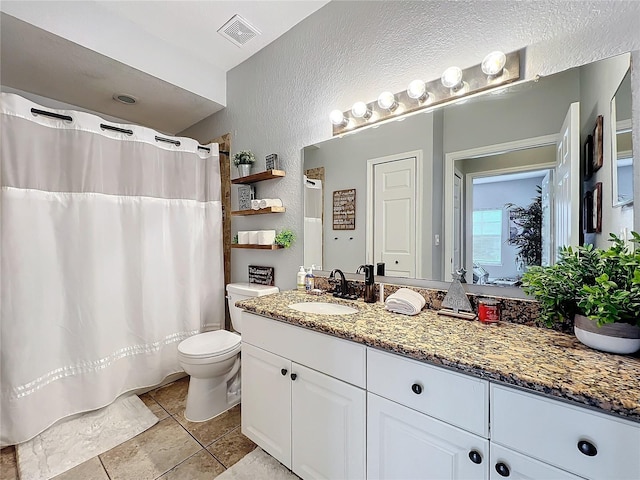 bathroom with tile patterned floors, curtained shower, vanity, and toilet