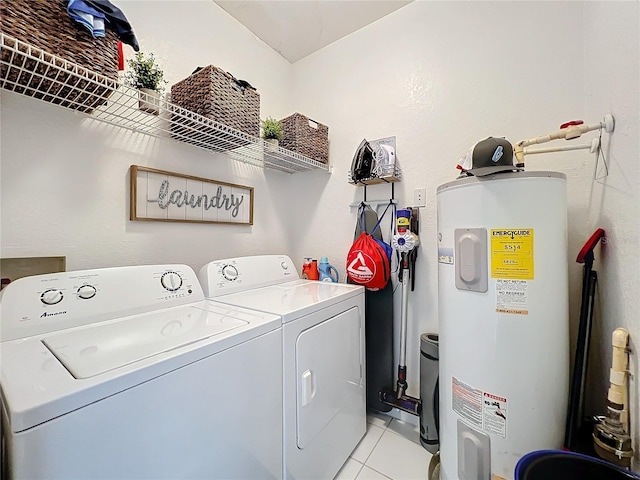 laundry room with light tile patterned floors, washing machine and dryer, and water heater