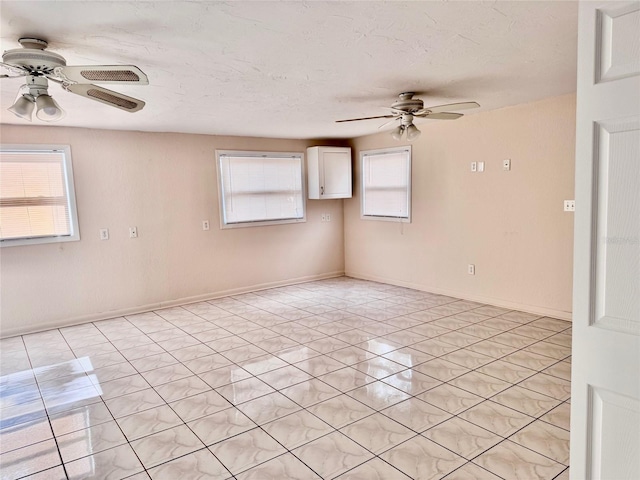 spare room with a textured ceiling and ceiling fan