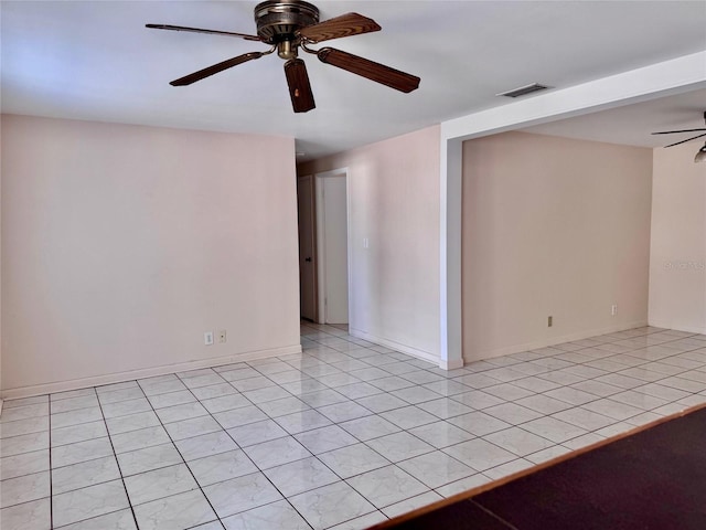 tiled spare room featuring ceiling fan