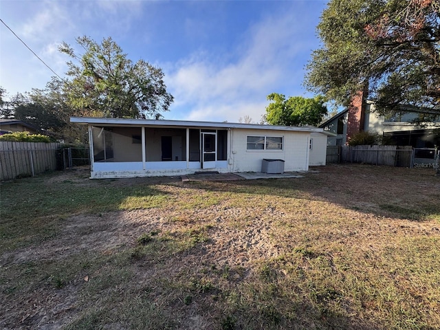 rear view of property featuring a lawn and a sunroom