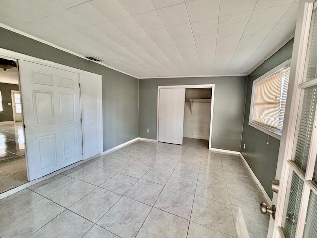 unfurnished bedroom with light tile patterned floors and ornamental molding