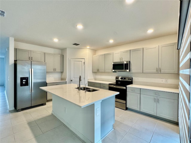 kitchen featuring light tile patterned floors, visible vents, appliances with stainless steel finishes, gray cabinetry, and a sink