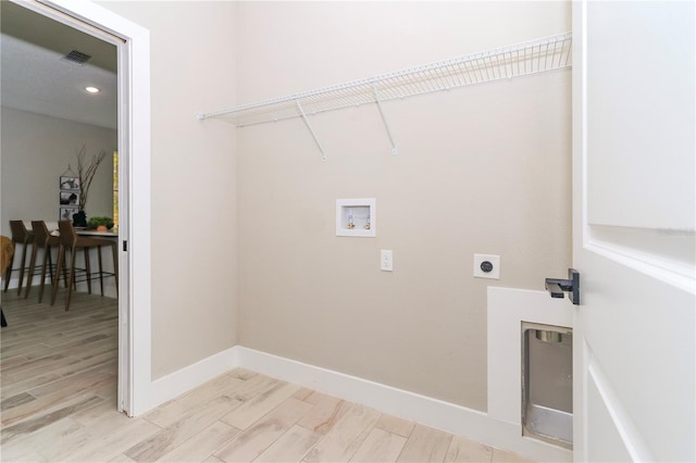 laundry room featuring hookup for an electric dryer, hookup for a washing machine, and light hardwood / wood-style flooring