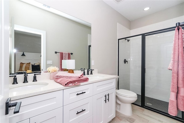 bathroom featuring vanity, toilet, and an enclosed shower