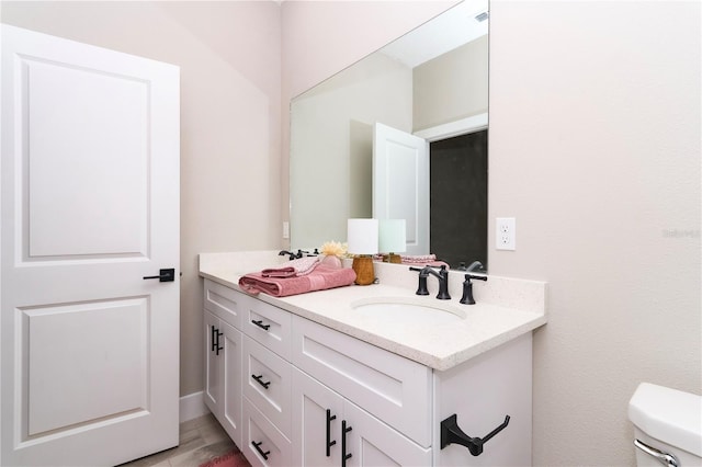 bathroom with vanity, wood-type flooring, and toilet