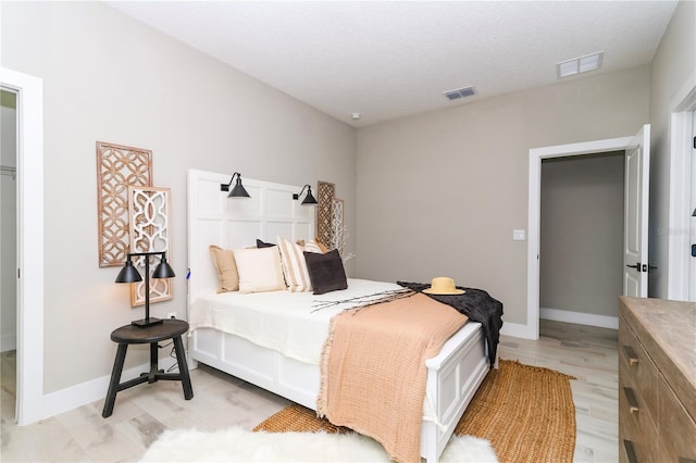 bedroom featuring a textured ceiling and light wood-type flooring