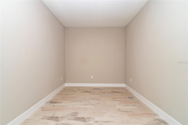 unfurnished room featuring light wood-type flooring and a textured ceiling