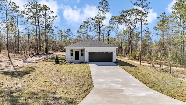 view of front of house with a shingled roof, a front yard, driveway, and an attached garage