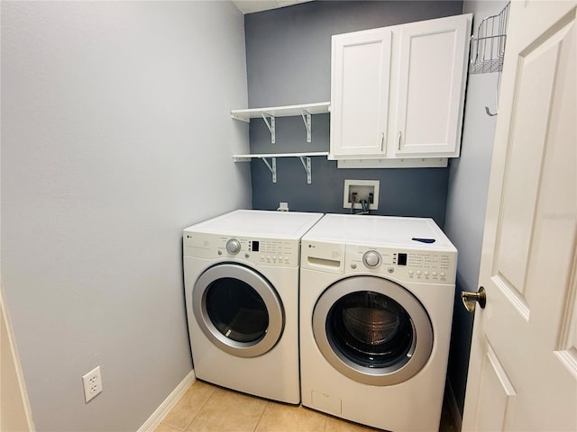 laundry area featuring cabinets, light tile patterned floors, and separate washer and dryer