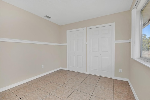 unfurnished bedroom with light tile patterned floors