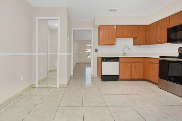 kitchen featuring dishwasher, stainless steel range with electric cooktop, light tile patterned flooring, and sink