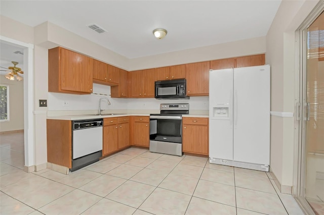 kitchen featuring ceiling fan, sink, light tile patterned floors, and white appliances