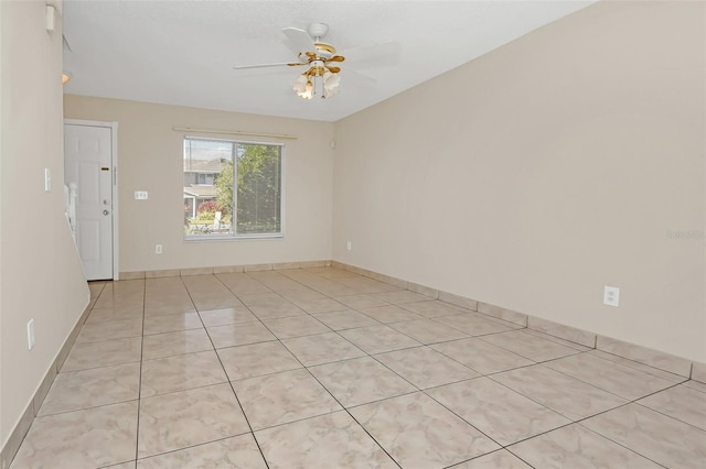 spare room with ceiling fan and light tile patterned floors