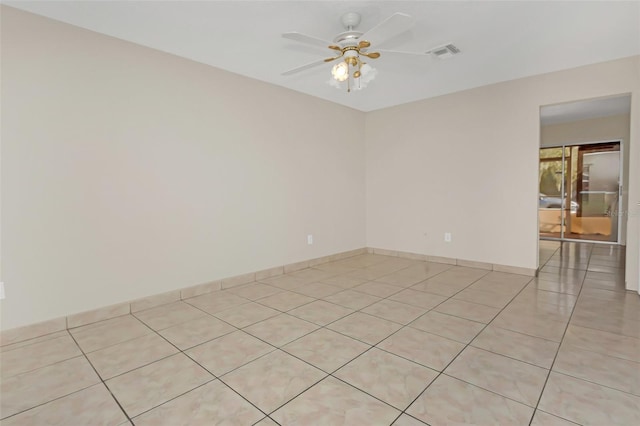 spare room with ceiling fan and light tile patterned floors