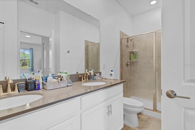 bathroom with tile patterned flooring, vanity, toilet, and walk in shower