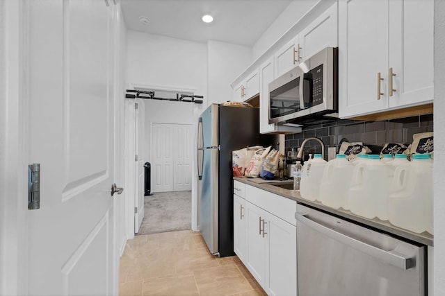 kitchen featuring backsplash, appliances with stainless steel finishes, sink, and white cabinets