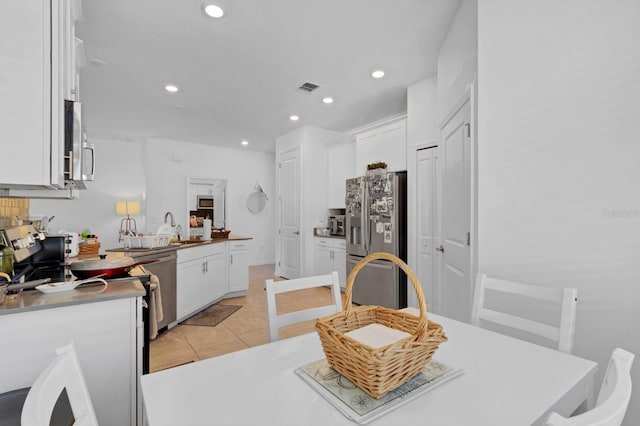 kitchen featuring light tile patterned floors, sink, white cabinetry, backsplash, and stainless steel appliances