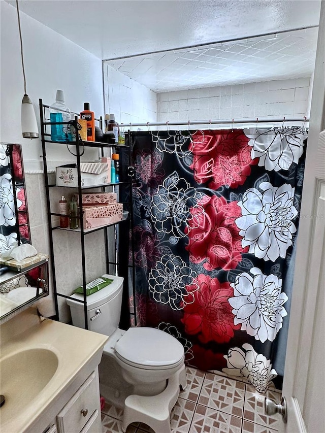 bathroom featuring vanity, toilet, and a textured ceiling