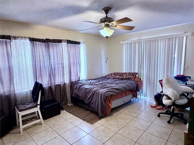 bedroom featuring light tile patterned floors, a textured ceiling, and ceiling fan