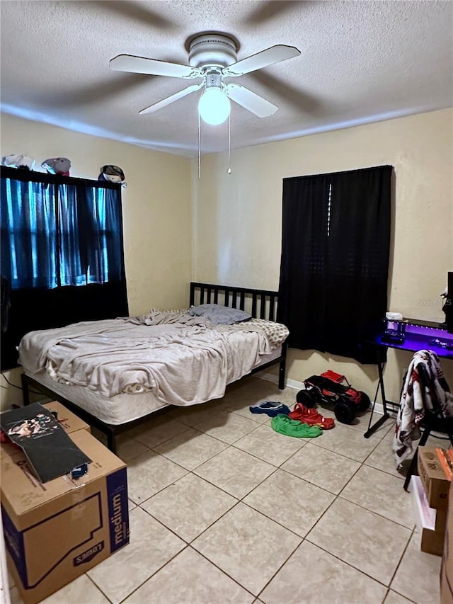 bedroom with light tile patterned flooring, ceiling fan, and a textured ceiling