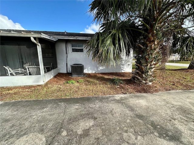 view of property exterior featuring cooling unit and a sunroom