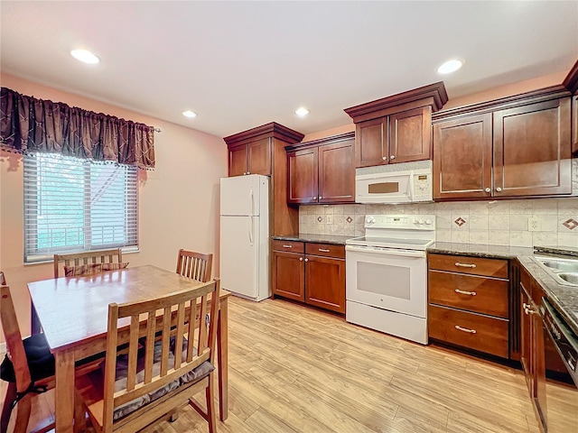 kitchen featuring light hardwood / wood-style floors, white appliances, sink, and tasteful backsplash