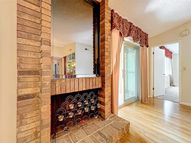 room details with a fireplace, hardwood / wood-style floors, and a textured ceiling