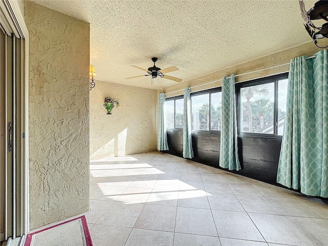 unfurnished sunroom with ceiling fan