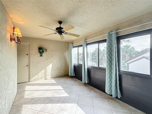 unfurnished sunroom with ceiling fan with notable chandelier