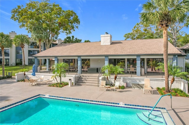 rear view of property featuring a patio and a community pool