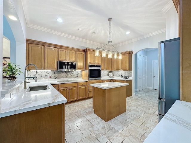 kitchen featuring sink, hanging light fixtures, decorative backsplash, a kitchen island, and appliances with stainless steel finishes