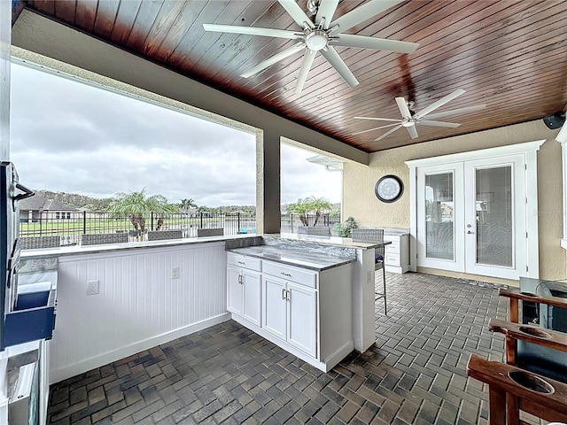 view of patio with ceiling fan, french doors, and an outdoor kitchen