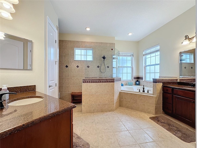 bathroom featuring tile patterned floors, vanity, and shower with separate bathtub