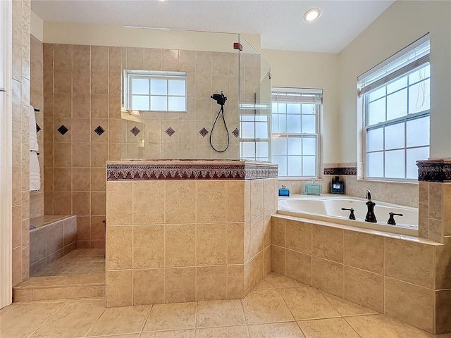 bathroom with tile patterned floors and shower with separate bathtub