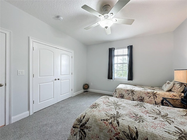 carpeted bedroom featuring a textured ceiling and ceiling fan