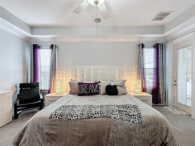 carpeted bedroom featuring a raised ceiling, ceiling fan, a textured ceiling, and access to outside