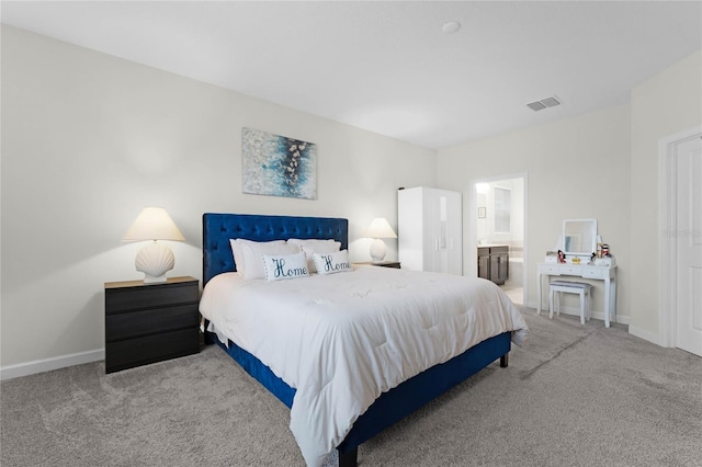 bedroom with light colored carpet and ensuite bath