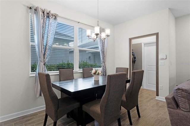 dining space featuring hardwood / wood-style floors and a chandelier