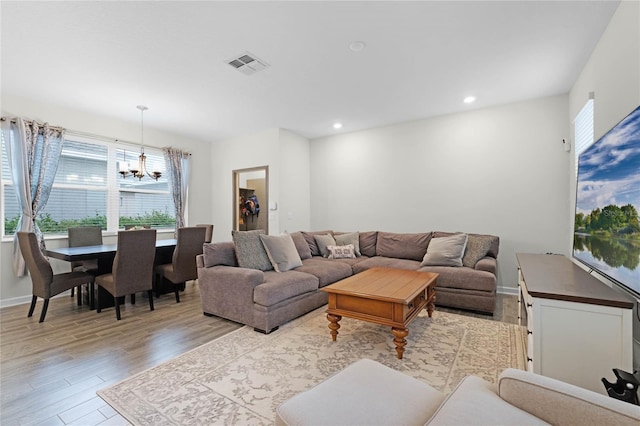 living room featuring a chandelier and light wood-type flooring