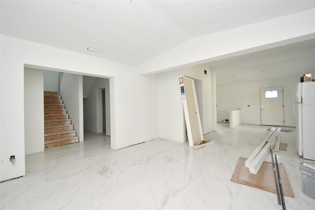 spare room featuring lofted ceiling